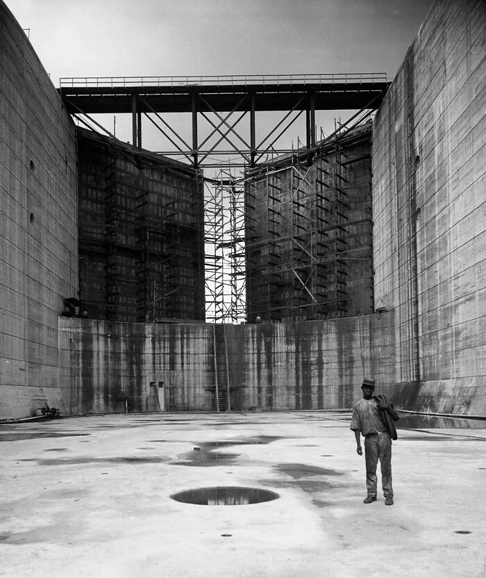 Un hombre de pie en el Canal de Panamá durante su construcción. 1912