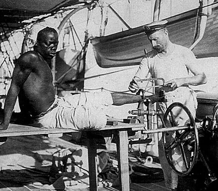 Un herrero británico quitando los grilletes a un esclavo, 1907, en la costa de Mozambique