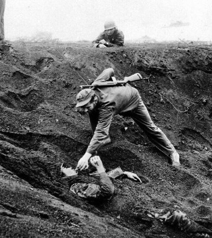 US Marine Gives A Cigarette To A Japanese Soldier Buried In Sand. Iwo Jima, 1945