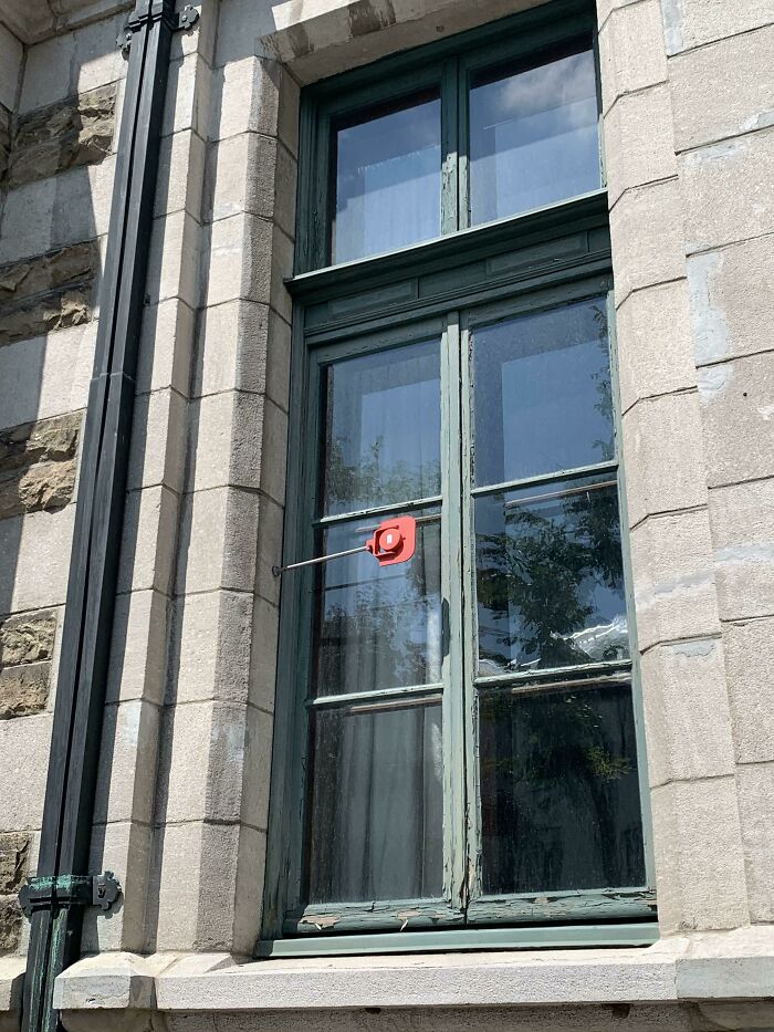 Small Red Flippable Plates Outside Windows In Montreal, Canada