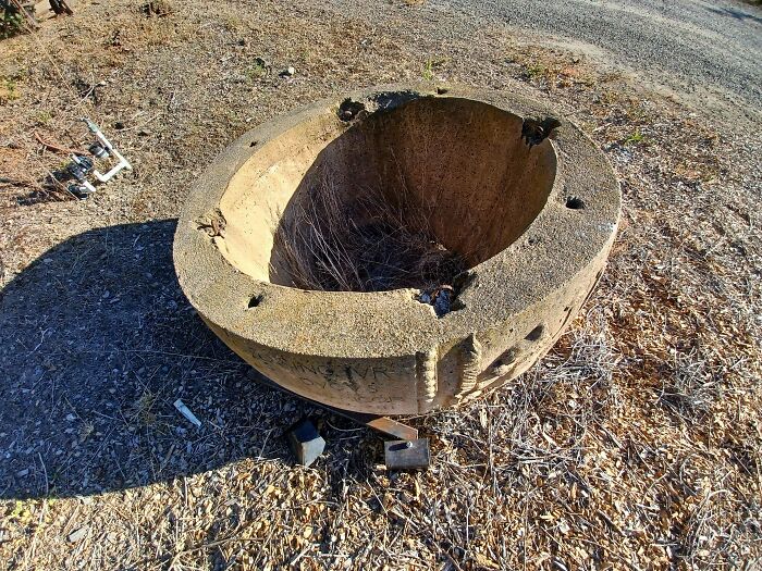 Big Concrete Object With Mysterious Text, 4 Holes And 4 Loops Along The Rim, Has No Bottom