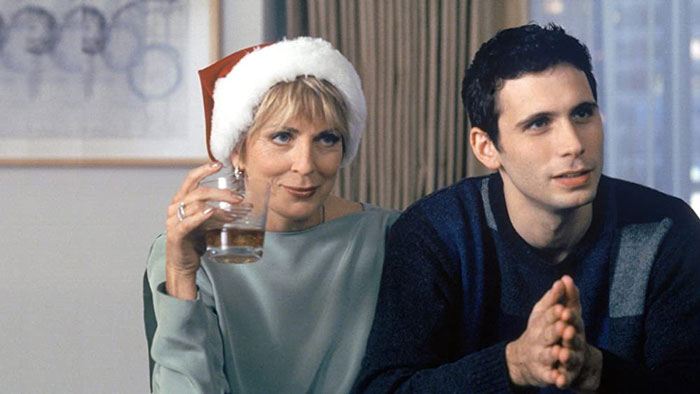 Margaret wearing a Santa cap holding a glass of whiskey 