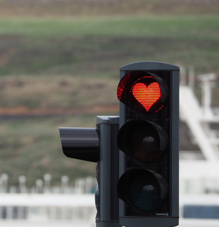 Traffic light with red heart symbol, representing relationship insights.