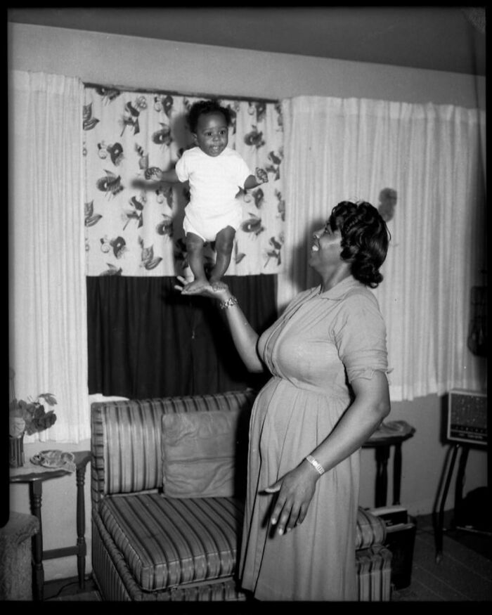 Una niña pequeña se balancea sobre la mano de su madre en Pittsburgh. Tomada a mediados de 1900