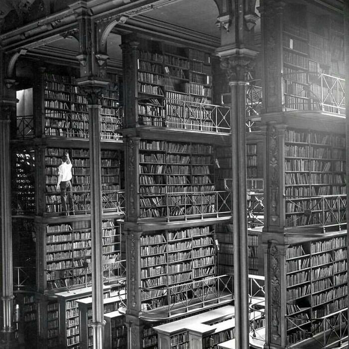 Un hombre mirando los libros de la Biblioteca Pública de Cincinnati. Fue demolida en 1955 