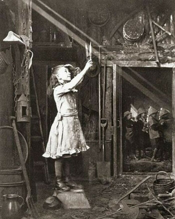 Una muchacha intentando cortar un rayo de sol. Esta foto fue tomada por Adam Diston en 1886