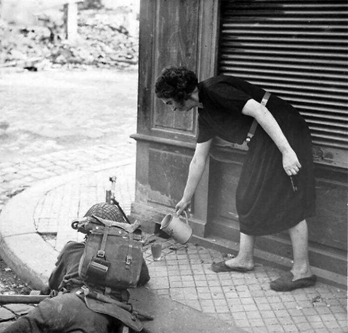 A French Women Pours Cider For A British Gunner In Lisieux, France, 22 August 1944