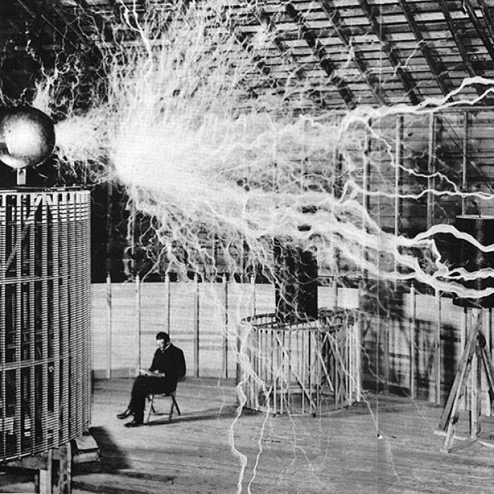 Nikola Tesla sentado en su laboratorio con su “transmisor de lupa”, diciembre de 1899 