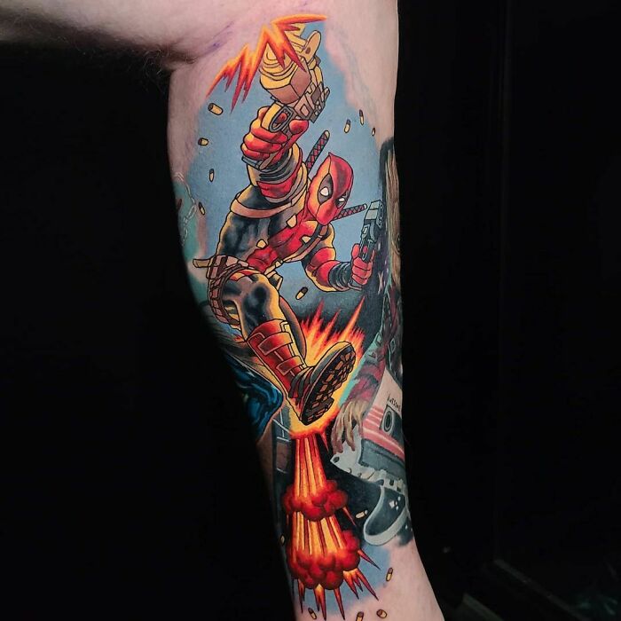 Marvel tattoo featuring a dynamic Deadpool design with vibrant colors and explosive action elements.