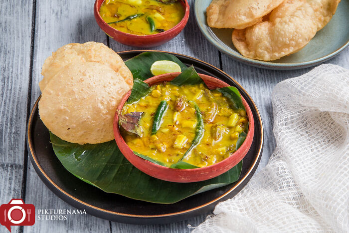 Luchi & Chhola'r Daal (Fried Puffed Bread With Bengal Gram Cooked With Coconut And Raisins)