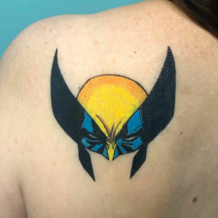 Marvel tattoo of Wolverine's mask on a person's shoulder.