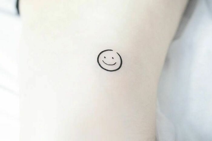 minimalistic tattoo of a smiley face