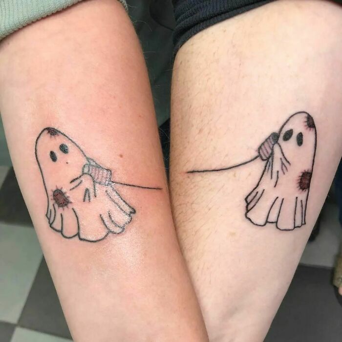 Matching ghost best friend tattoos on two arms, symbolizing friendship.