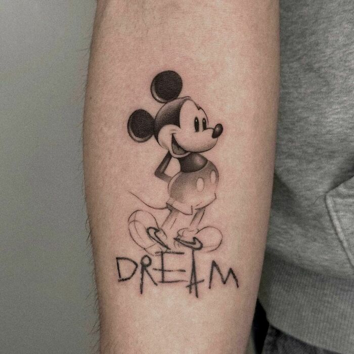 Mickey Mouse standing on the "Dream" inscription tattoo 