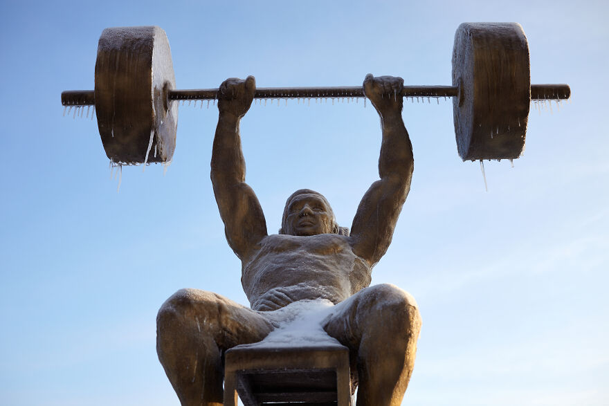 Sculptures Of Athletes Covered With Ice After An Icy Rain
