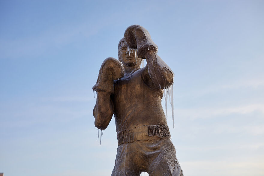 Sculptures Of Athletes Covered With Ice After An Icy Rain
