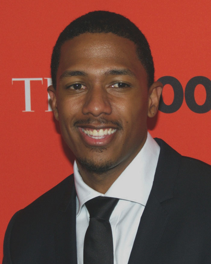 Nick Cannon wearing suit and smiling