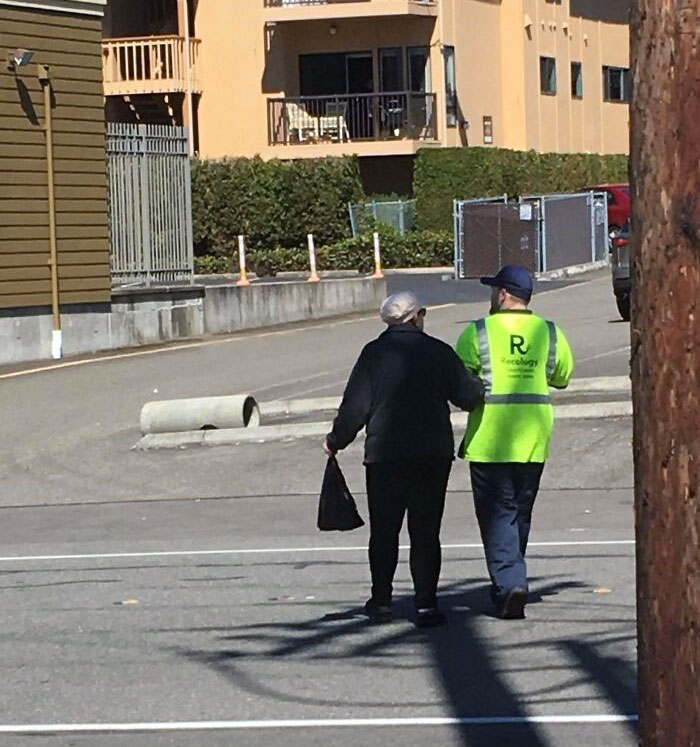 Recology Worker Helps An Elderly Woman Cross The Street With Her Groceries