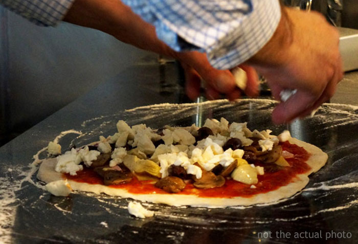 Pizza Maker Tries To Explain To Couple That They Ordered Too Many Toppings And The Pizza Won’t Cook, They Insist And The Worker Maliciously Complies