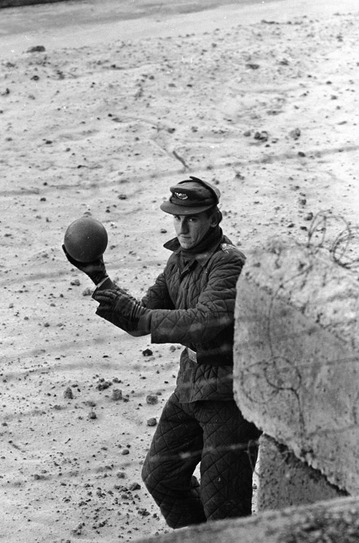 Un guardia de Alemania Oriental devuelve un balón a un niño que juega en el lado de Alemania Occidental del Muro de Berlín. 1962