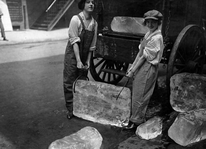 Two Women Working As Ice Deliverers Carry A Large Block Of Ice. September 1918