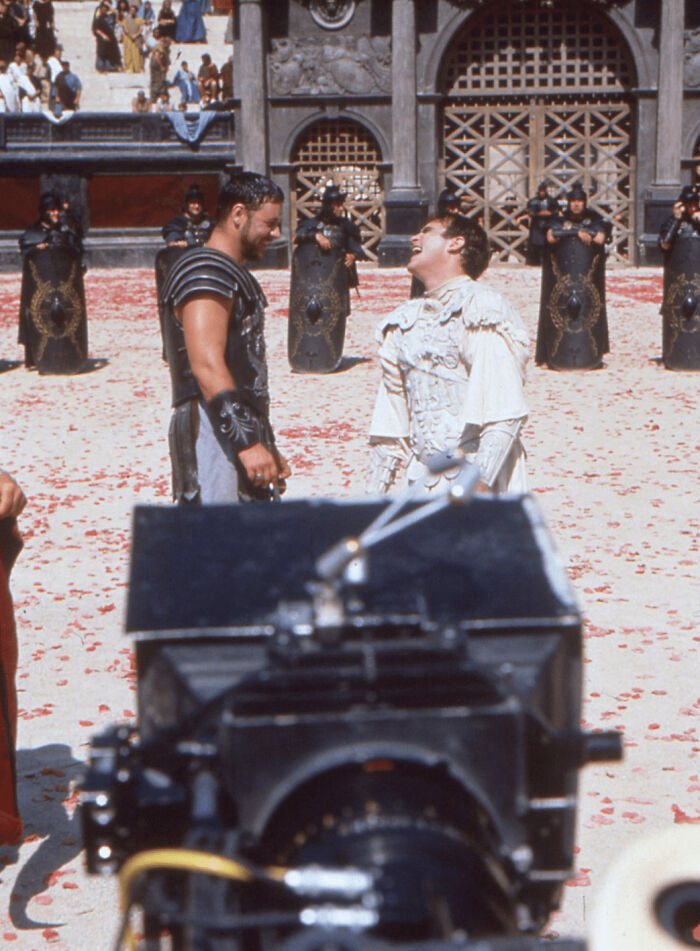 Russell Crowe, cigarrillo en mano, y Joaquin Phoenix comparten una broma durante el rodaje de su duelo final para Gladiator (1999)