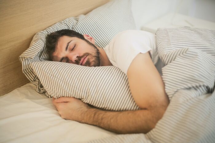Man Comfortably Sleeping In Bed 