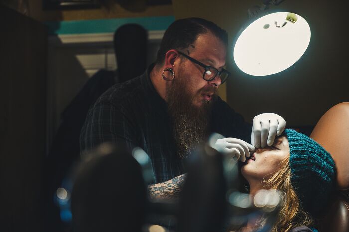 Woman Is Piercing Her Nose By A Piercing Artist 