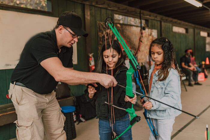 Archery Teacher Teaching Girl How To Shoot From A Bow 