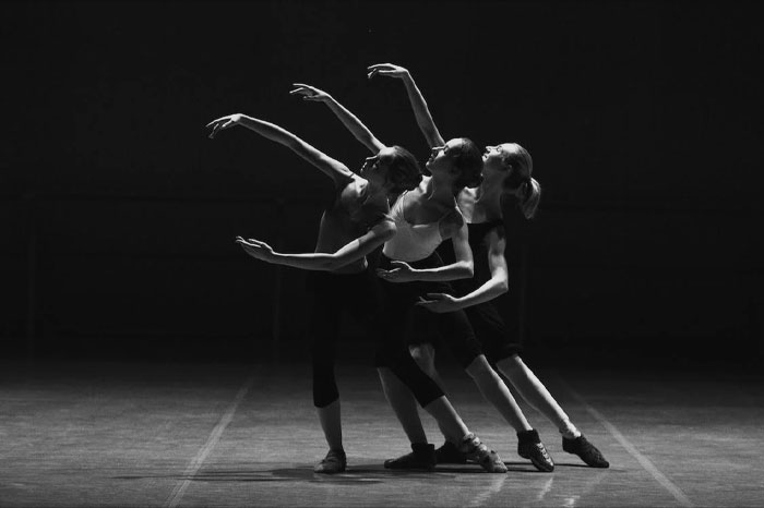 Three women dancing ballet on stage 