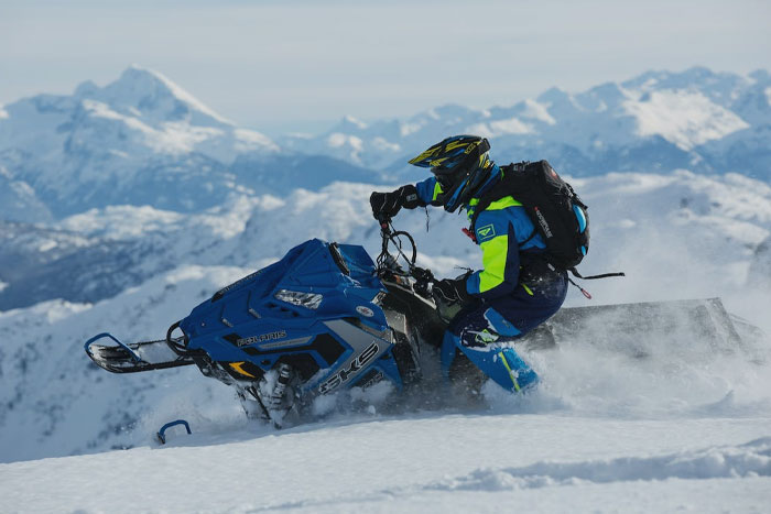 Man Driving A Snowmobile in mountains 