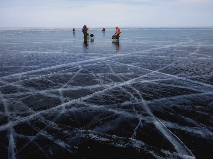 Multiple people fishing on frozen lake 