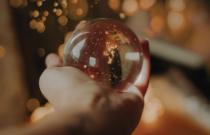 Person holding a glass snow globe in a hand 