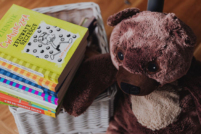 Toy bear near multiple books 