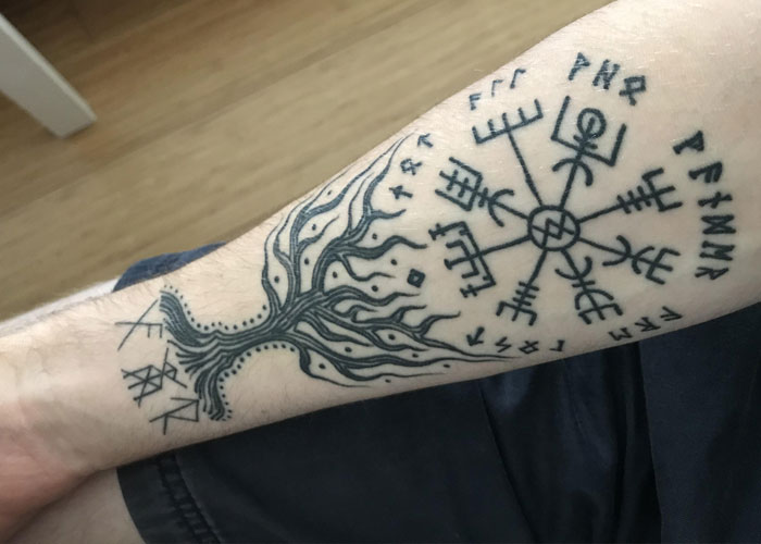 Tattoo with runes and tree design on forearm, related to debate about Christian boss and 'evil' employee ideas. Tattoo with runes and tree design on forearm, related to debate about Christian boss and 'evil' employee ideas.