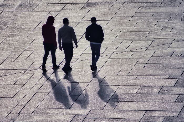 three man walking down the street 