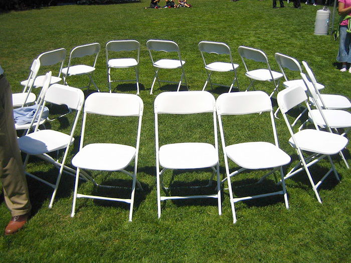 white chairs by circle on the grass