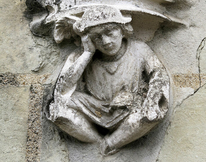 a statue of a person sitting with legs crossed 