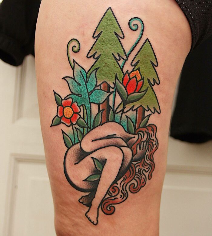Woman with flowers and trees leg tattoo