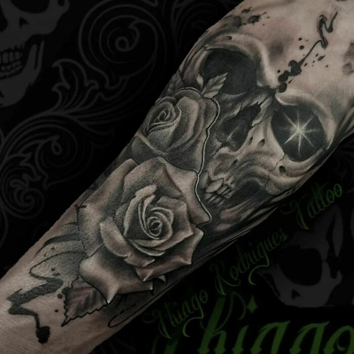 Skull with roses arm tattoo