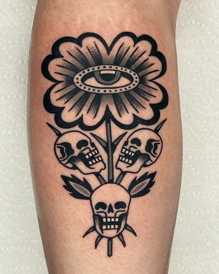 Trippy skulls and flower with eye arm tattoo