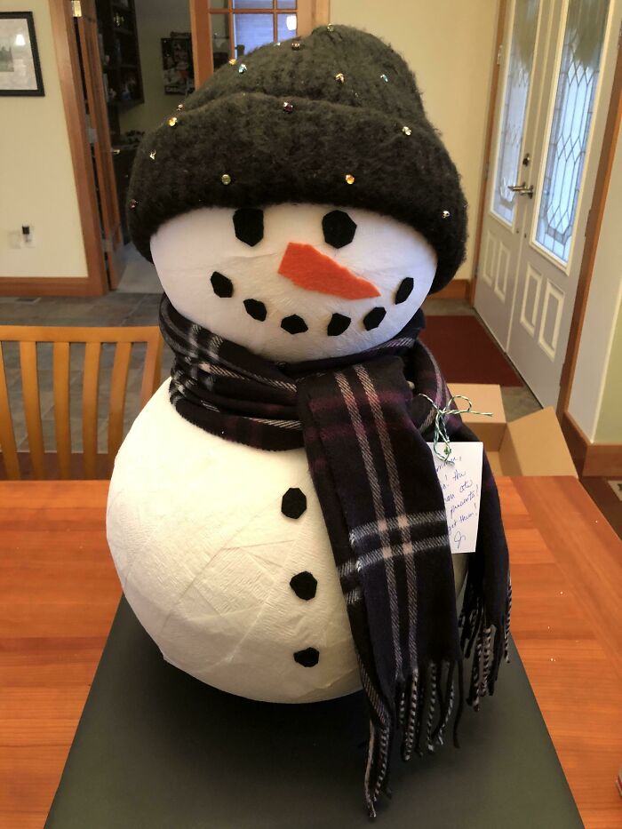 Un muñeco de nieve. La cabeza y el cuerpo son de telgopor hueco y sostienen los regalos. Le añadí una bufanda y un gorro para adornar 
