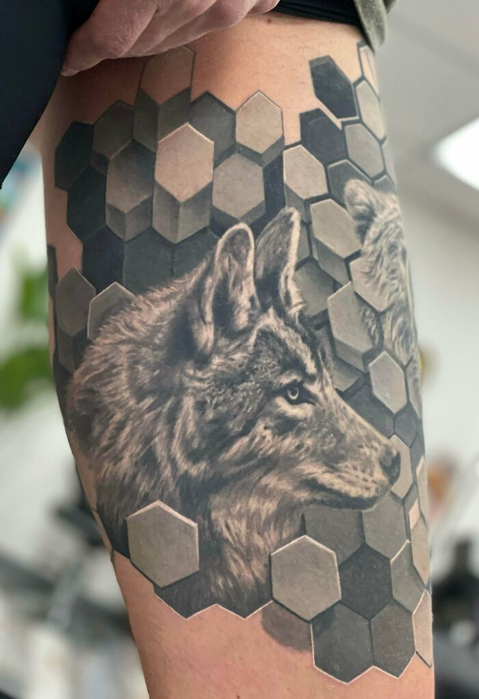  A psychedelic, hexagonal matrix with wolf thigh half-sleeve arm tattoo