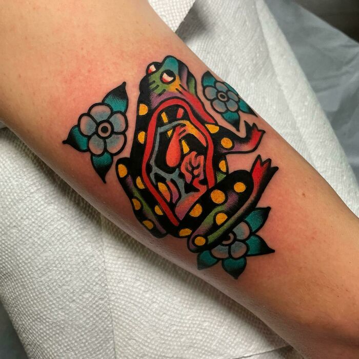 Colorful psychedelic frog with flowers arm tattoo