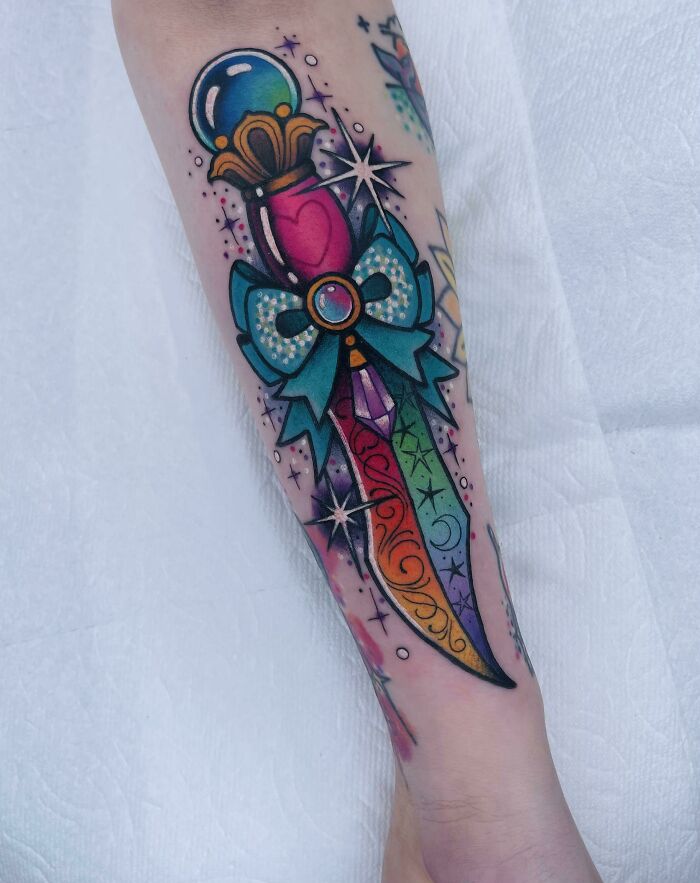 Colorful rainbow dagger with stars arm tattoo