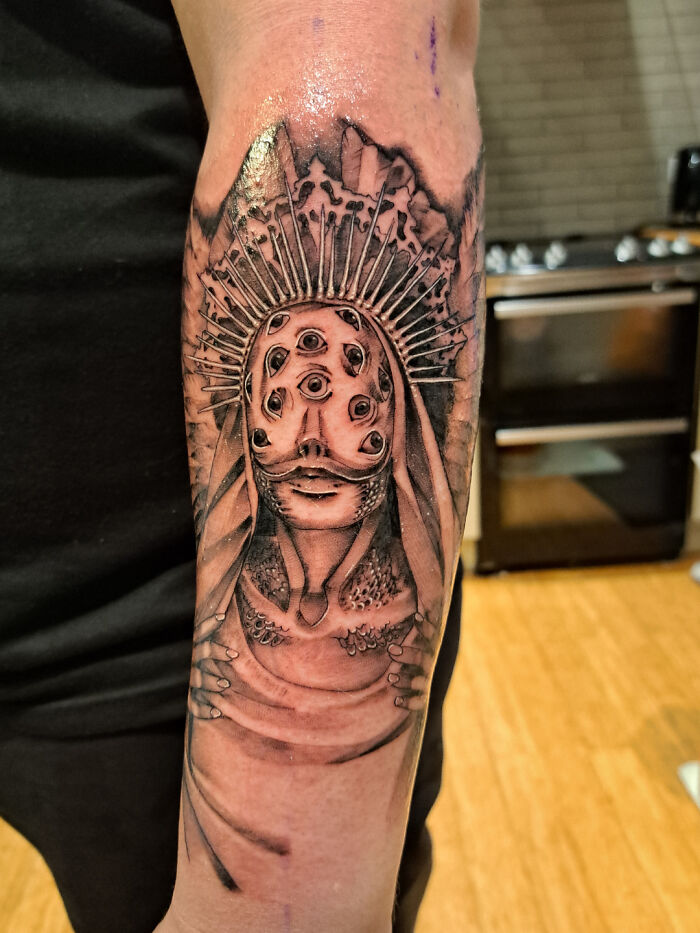 Trippy monster with eyes arm tattoo
