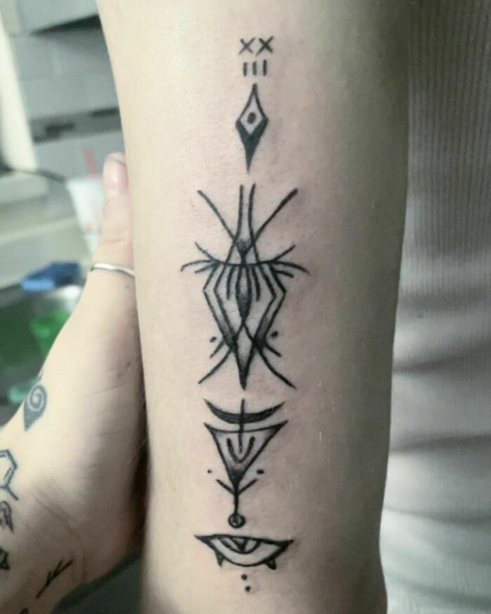 Trippy symbols arm tattoo