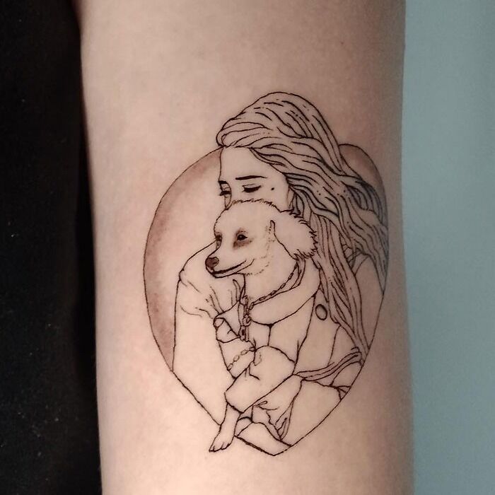 Woman hugging her dog tattoo 