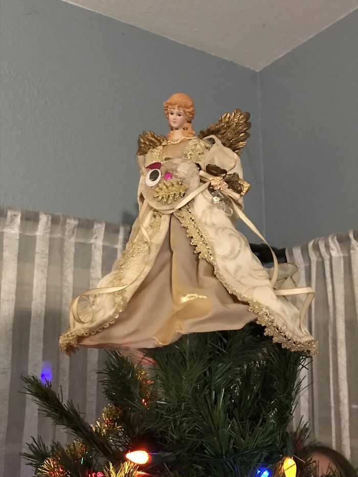 We Call It The "Derp Ornament." My Older Brother Made It Out Of A Sand Dollar In 2016 And Has Put It Around The Angel's Neck Ever Since