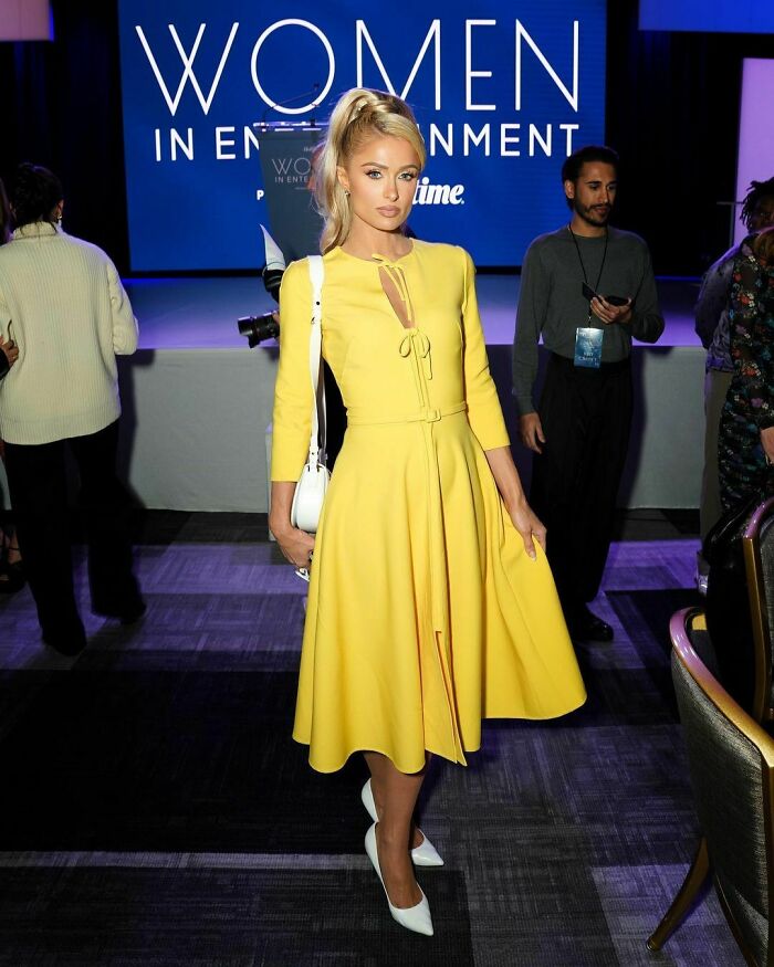 Blonde celebrity wearing a yellow dress and white heels at a Women in Entertainment event, representing smartest celebrities.